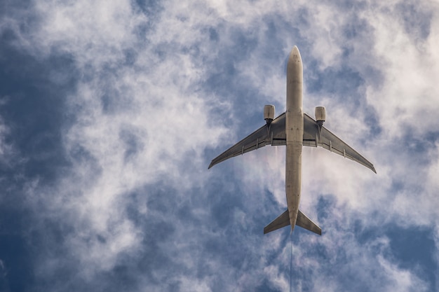 Aeroplano su cielo blu con nuvole. Viaggia per il mondo nell'aria