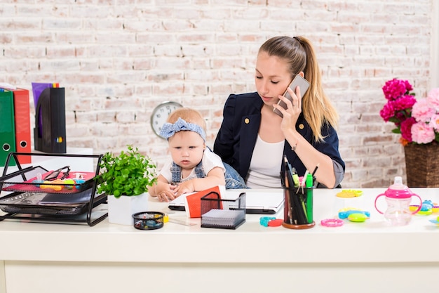 Affari di famiglia - telelavoro La donna d'affari e la madre con il bambino stanno facendo una telefonata