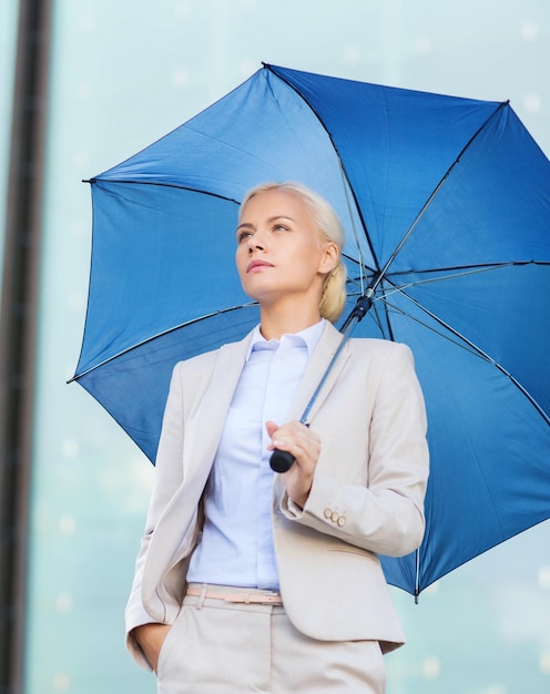 affari, maltempo e persone e concetto - giovane donna d'affari seria con ombrello all'aperto