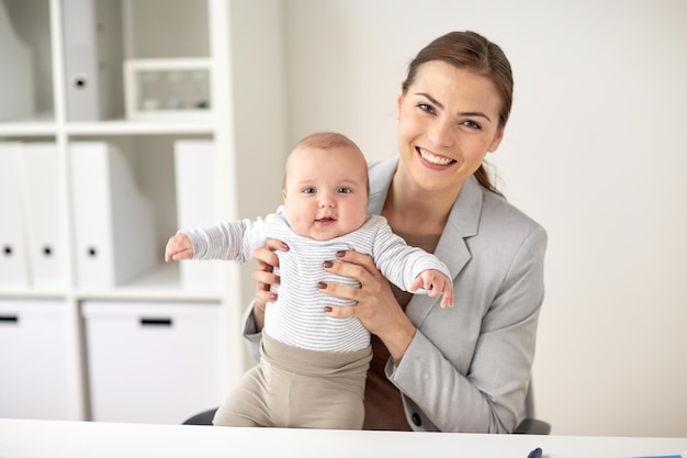 affari, maternità, multi-tasking, famiglia e concetto di persone - felice sorridente donna d'affari con bambino in ufficio
