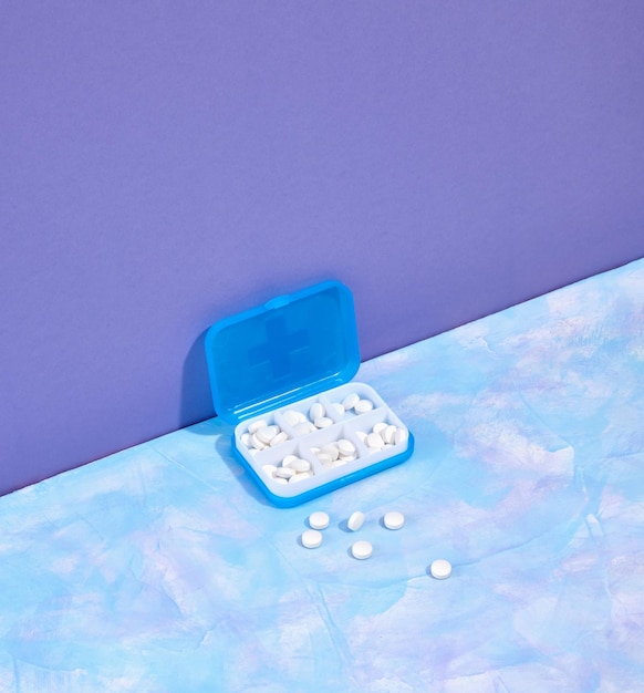 Affari sanitari Contenitore medico di blu con pillole bianche sul tavolo Concetto di stile di vita sano
