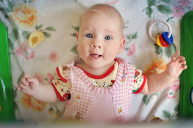 Affascinante bambina sorride e gioca con i giocattoli.