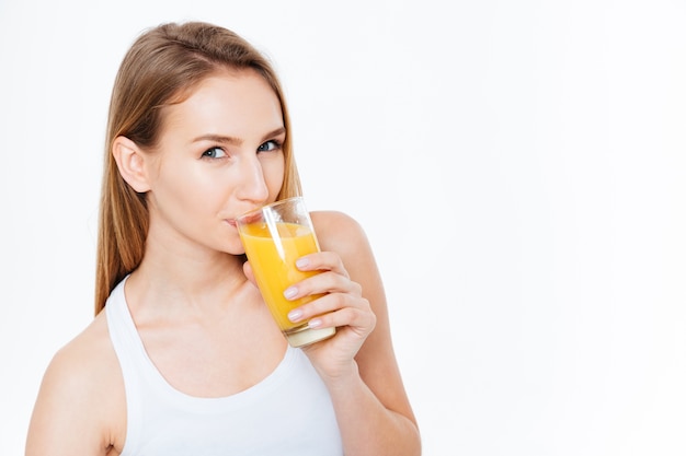 Affascinante donna che beve succo fresco isolato su uno sfondo bianco