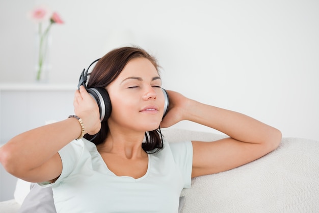 Affascinante donna dai capelli scuri che ascolta la musica