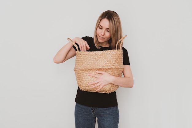 Affascinante donna europea in abiti casual con cesto in mano