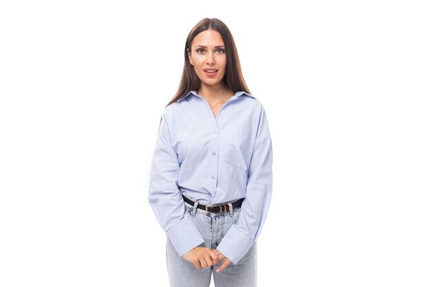 Affascinante giovane bruna caucasica donna con i capelli dritti è vestita con una camicia blu cielo su