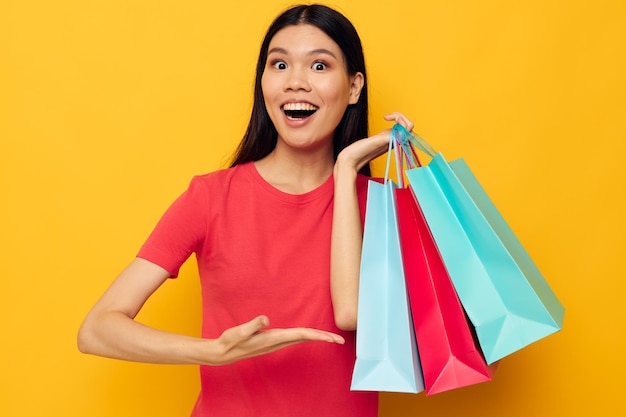 Affascinante giovane donna asiatica con borse colorate in posa shopping divertente stile di vita inalterato