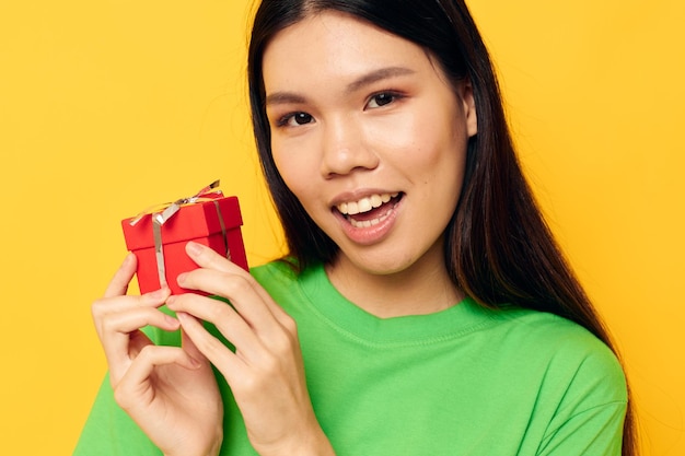 Affascinante giovane donna asiatica in magliette verdi con una piccola confezione regalo Stile di vita inalterato