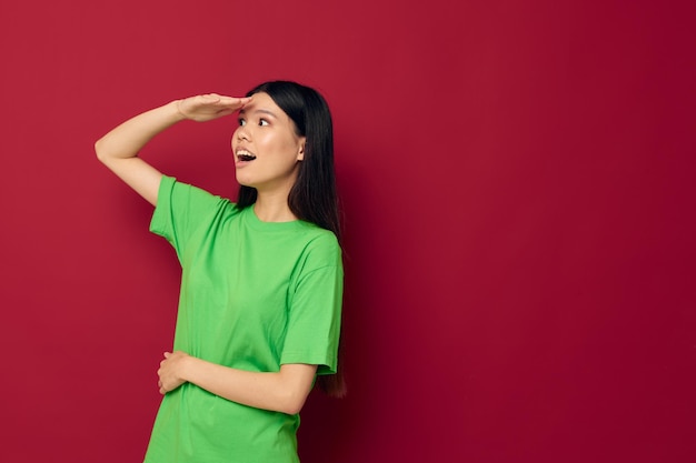 Affascinante giovane donna asiatica maglietta verde gesti con il suo modello di studio delle mani inalterato