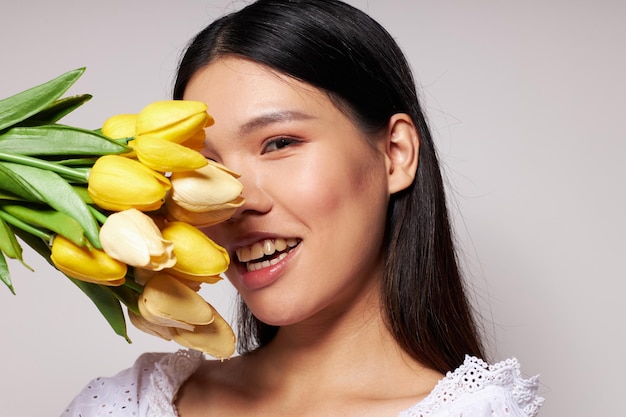 Affascinante giovane donna asiatica romantico bouquet di fiori vicino allo stile di vita del viso inalterato