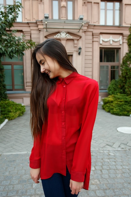 Affascinante giovane donna con magnifici capelli castani, occhi grandi, splendido rossetto rosso e look elegante