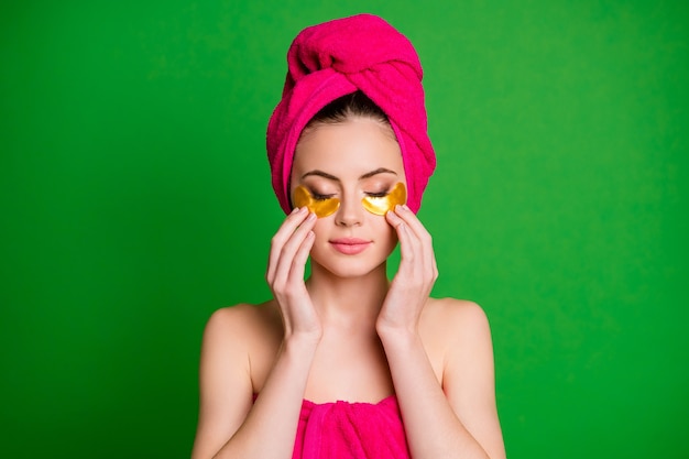 Affascinante signora dopo la doccia usa i cerotti gli occhi chiusi tocca la pelle indossa gli asciugamani sulla testa del corpo isolato sfondo di colore verde