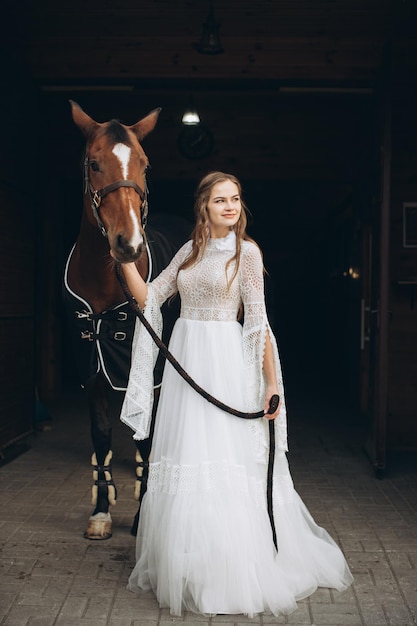 Affascinante sposa in stile boho in un ranch con un cavallo
