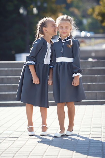 Affascinanti bambine in abito retrò a piedi in città in una soleggiata giornata estiva.