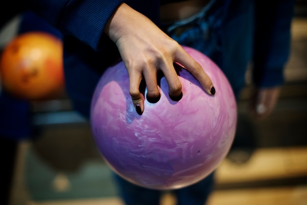 Afferrando la palla da bowling rosa