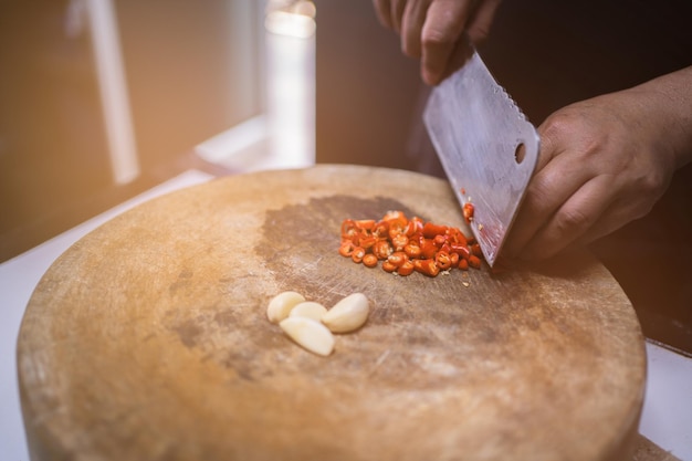 Affettare a mano il peperoncino con il coltello sul tagliere