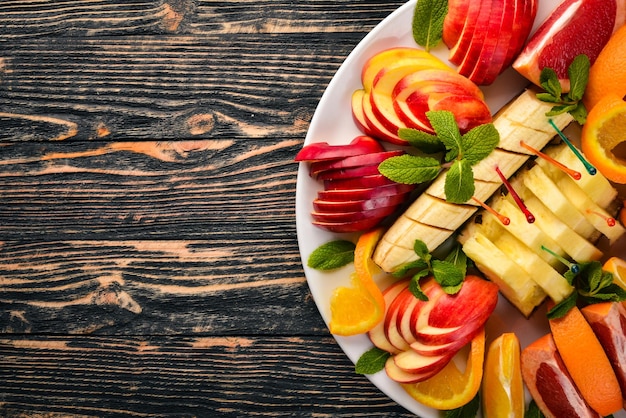 Affettare Frutta Arance Pompelmo Banana Mandarino Kiwi Tagliateli Spazio libero per il testo Vista dall'alto