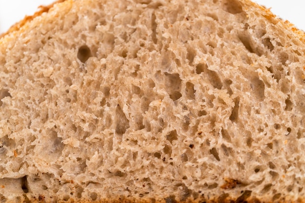 Affettare il pane di segale a lievitazione naturale appena sfornato su un tagliere bianco