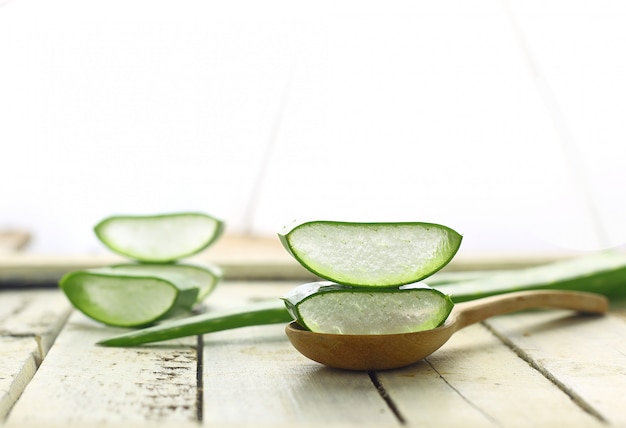 Affettato aloe vera su cucchiaio a base di erbe medicinali per pelle e capelli su bianco