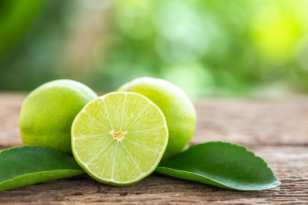 Affetti il ​​limone fresco verde sul fondo di legno della tavola