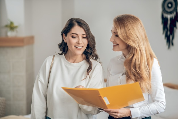 Affitto dell'appartamento. Giovane donna che parla con un agente immobiliare dell'affitto di un appartamento e sembra coinvolta