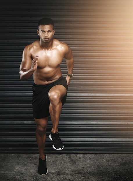 Affronta i tuoi obiettivi di fitness a testa alta Inquadratura di un giovane uomo in forma e senza maglietta che corre