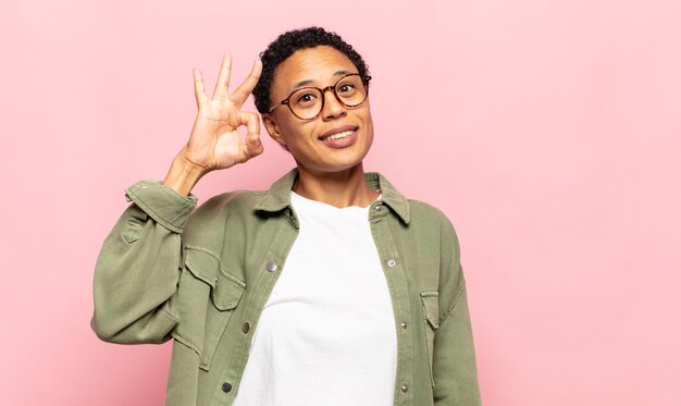 afro giovane donna nera sentirsi di successo e soddisfatta, sorridente con la bocca spalancata, facendo segno bene con la mano