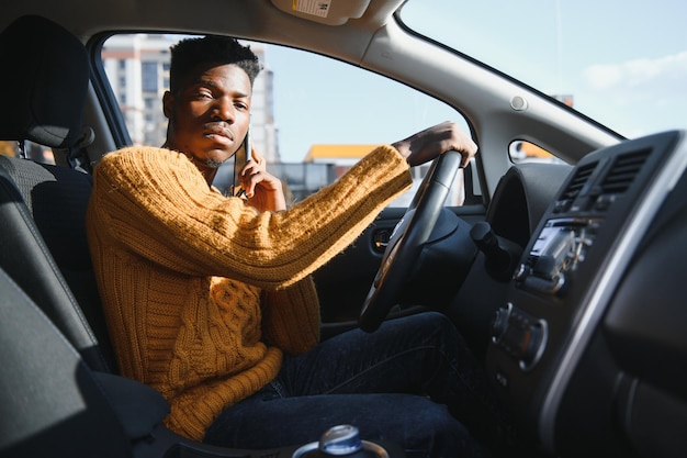 Afroamericano alla guida di un'auto elettrica.