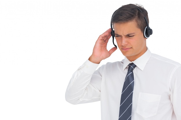 Agente del call center utilizzando l&#39;auricolare e toccandolo