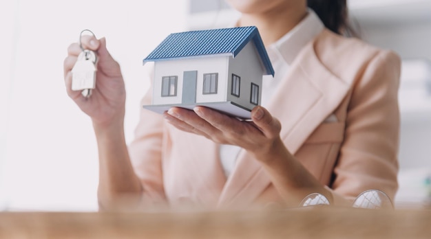 Agente di intermediazione immobiliare che presenta e consulta il cliente per prendere decisioni firmare un contratto di assicurazione per l'acquisto e la vendita di un modello di casa relativo all'offerta di mutuo ipotecario e all'assicurazione sulla casa