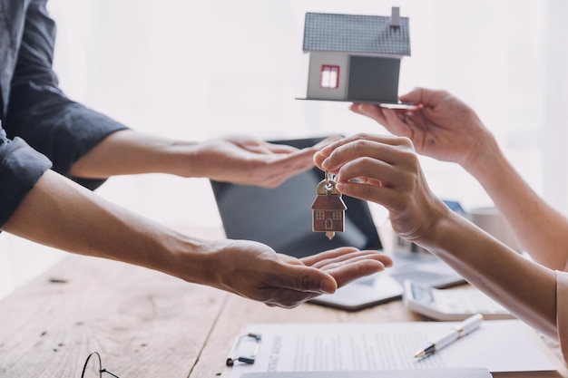 Agente di intermediazione immobiliare che presenta e consulta il cliente per prendere decisioni firmare un contratto di assicurazione per l'acquisto e la vendita di un modello di casa relativo all'offerta di mutuo ipotecario e all'assicurazione sulla casa