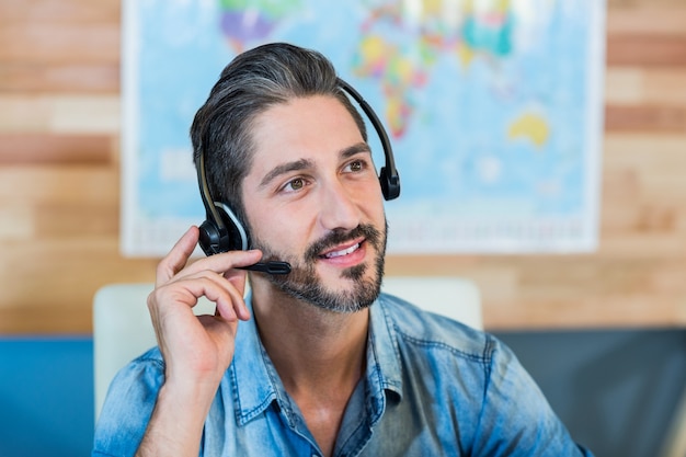 Agente di viaggio sorridente che ha telefonata