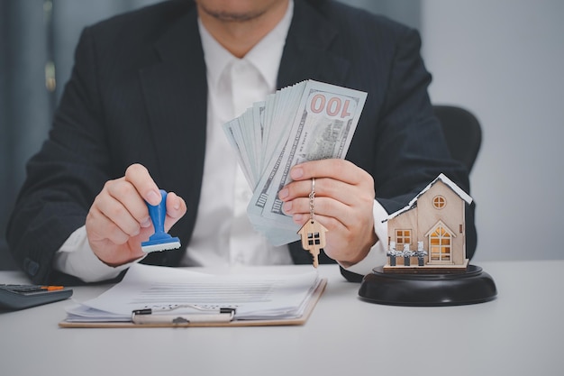Agente immobiliare che timbra il documento di prestito approvato in ufficio concetto di prestito immobiliare e investimenti