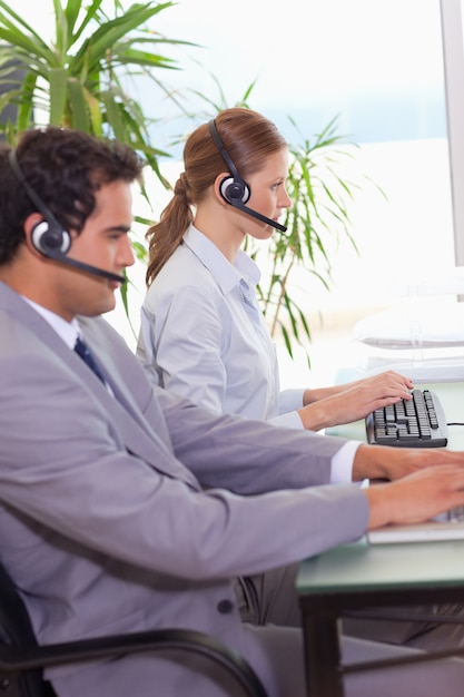 Agenti del call center che lavorano l&#39;uno accanto all&#39;altro