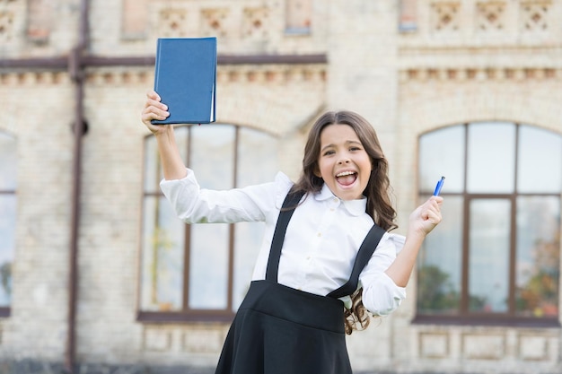 Agganciato all'apprendimento Carino bambino sorridente tenere libro Supera il test con successo Studentessa di scuola bambina Concetto di istruzione scolastica Giornata della conoscenza Lingua di apprendimento I migliori libri di testo per l'apprendimento a casa