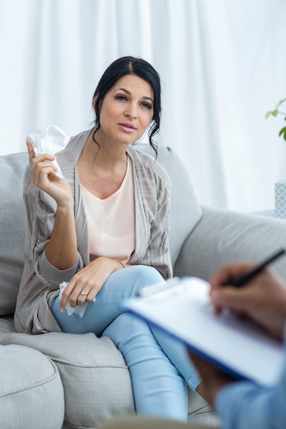 Aggiusti la scrittura sulla lavagna per appunti mentre consultano la donna incinta a casa