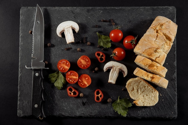 Aglio aglio su fondo nero con pomodori e funghi