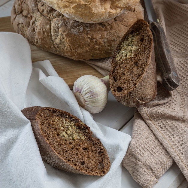 Aglio di pane fresco cotto in casa su un tovagliolo beige e un tavolo di legno