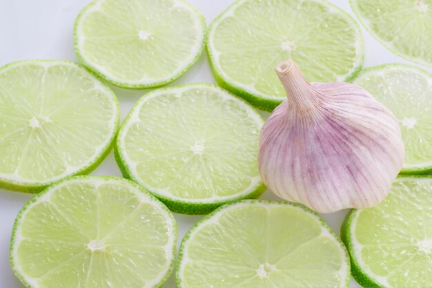 Aglio e fette di limone su sfondo bianco