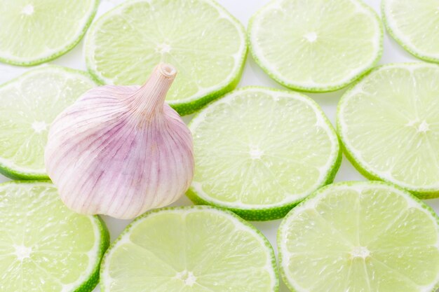 Aglio e fette di limone su sfondo bianco