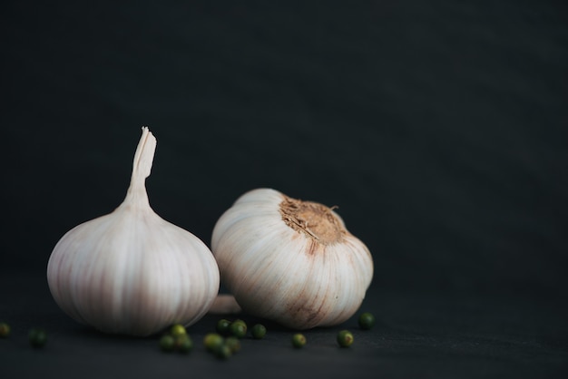 Aglio e pepe verde sul tavolo di pietra nera