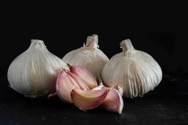 Aglio e spicchi d'aglio isolati su sfondo nero