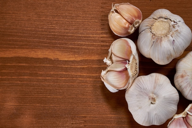 Aglio e spicchi d&#39;aglio su fondo in legno.