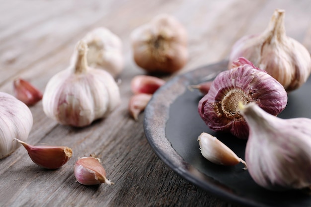 Aglio fresco con piatto sulla tavola di legno