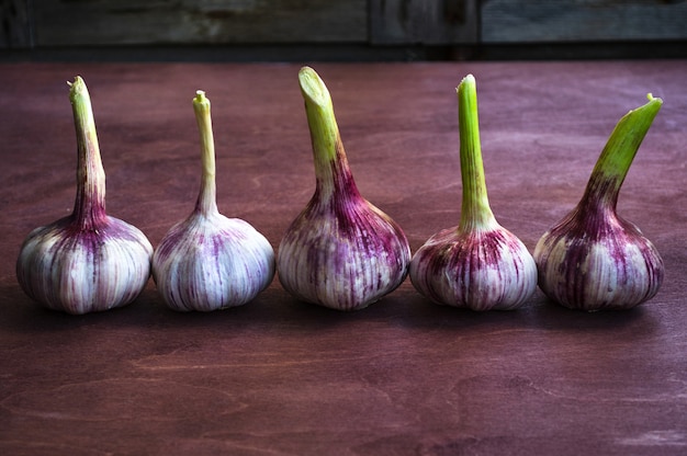 Aglio viola su un tavolo in legno marrone.