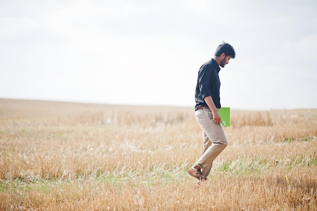 Agricoltore agronomo dell'Asia meridionale che ispeziona l'azienda agricola del campo di grano Concetto di produzione agricola