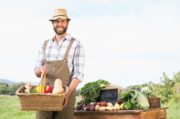 Agricoltore che tiene il cesto di verdure al mercato