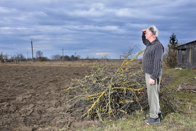 Agricoltore in piedi sul campo. Tempo di primavera. Inizio lavori di primavera sul campo