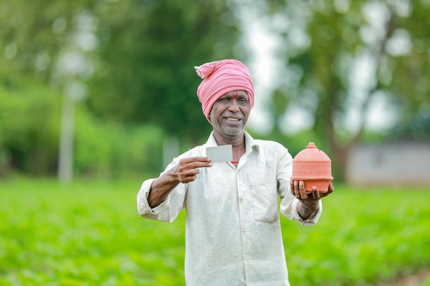 Agricoltore indiano Holding gullak in mano concetto di risparmio felice povero agricoltore