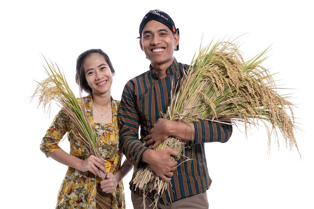 Agricoltori asiatici felici che tengono i chicchi di riso